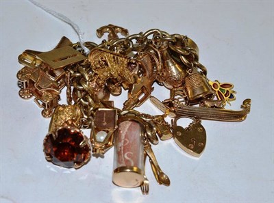 Lot 230 - A charm bracelet hung with twenty four charms - mostly 9ct gold charms