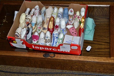 Lot 294 - A collection of miniature porcelain shoes together with a purpose made Swan Man oak display cabinet