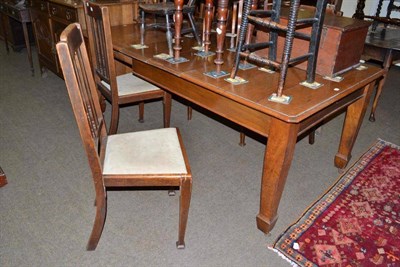 Lot 520 - An oak telescopic dining table and four chairs