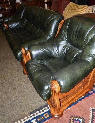 Lot 576 - An oak framed green leather three piece suite and a foot stool