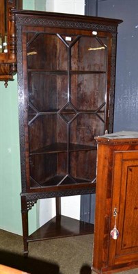 Lot 619 - An Edwardian corner cabinet with blind fret carved decoration