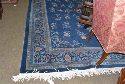 Lot 645 - Machine made carpet of Chinese design Europe, the mid indigo field with columns of floral...