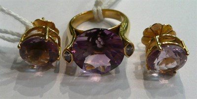 Lot 64 - An amethyst and diamond ring, a round cut amethyst flanked by a marquise cut diamond on each...