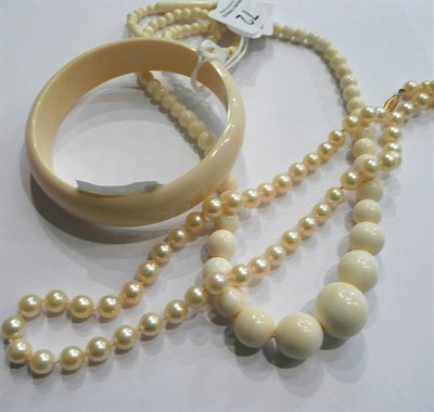 Lot 72 - A cultured pearl necklace stamped '14K', a bead necklace and a bangle