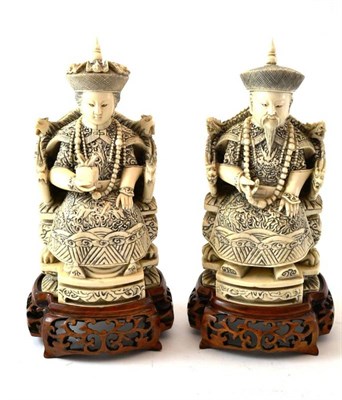 Lot 213 - A Pair of Chinese Ivory Figures of Dignitaries, circa 1900, each sitting on a throne wearing...