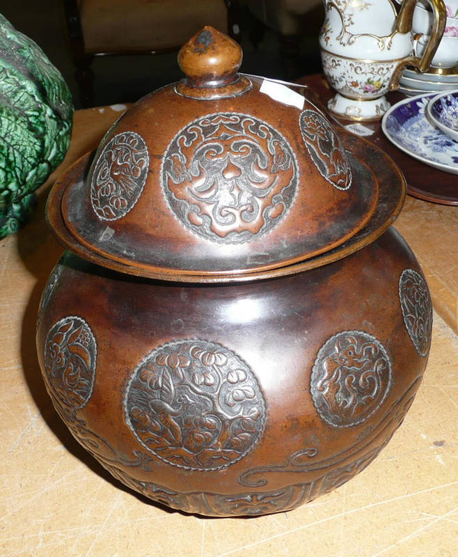 Lot 497 - A Chinese copper repousse measure and engraved compressed jar and cover