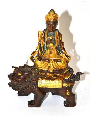 Lot 228 - A Chinese Parcel Gilt Bronze Figure of Buddha, Qing Dynasty, sitting on the back of a lion dog...