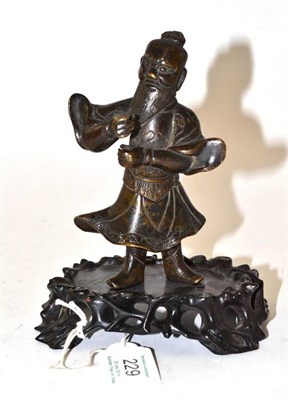Lot 229 - A Chinese Bronze Figure of a Sage, probably 17th century, the bearded figure standing wearing...