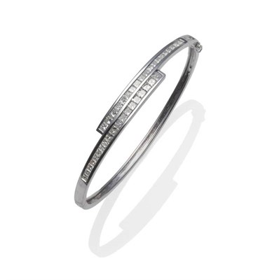 Lot 314 - A Diamond Bangle, of crossover design, princess cut diamonds in a white channel setting to the...