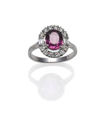 Lot 321 - An 18 Carat White Gold Pink Sapphire and Diamond Cluster Ring, the oval mixed cut sapphire within a