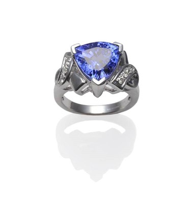 Lot 324 - An 18 Carat White Gold Tanzanite and Diamond Ring, a trilliant cut tanzanite in a white claw...