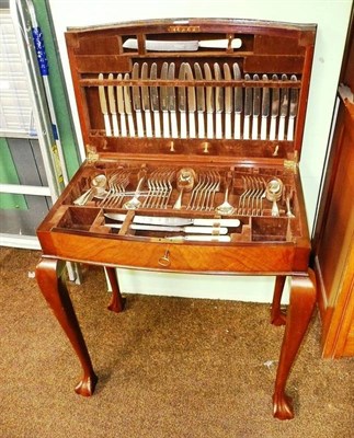 Lot 636 - Canteen of plated cutlery (twelve place setting) in a walnut veneered box on cabriole legs (missing