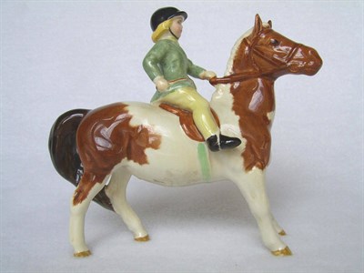 Lot 1113 - Beswick Girl on Skewbald Pony, model No. 1499, brown and white pony, rider in green jacket...