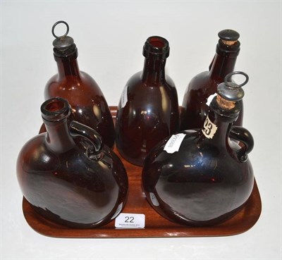 Lot 22 - Five amber glass spirit flasks, three with stoppers