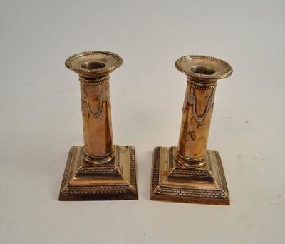 Lot 56 - A pair of small silver column candlesticks