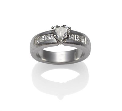 Lot 361 - A Platinum Diamond Ring, a heart shaped diamond in a white claw setting sits over a broad...