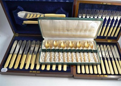 Lot 159 - A cased set of fish cutlery, cased set of fruit cutlery and a set of gilt spoons and forks