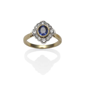 Lot 369 - An 18 Carat Gold Sapphire and Diamond Cluster Ring, the oval cut sapphire in a yellow...