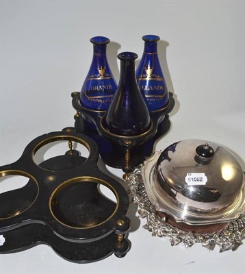 Lot 177 - A pair of Georgian black papier mache bottle stands with three blue decanters, a plated muffin dish