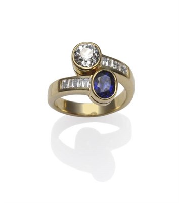 Lot 373 - A Sapphire and Diamond Crossover Ring, a yellow band with three step cut diamonds channel set...