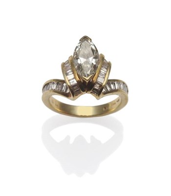 Lot 375 - A Diamond Ring, a marquise diamond in yellow claws, within 'fold-over' shoulders channel set...