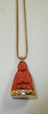 Lot 228 - A coral Buddha type pendant in frame, on a 9ct gold box chain