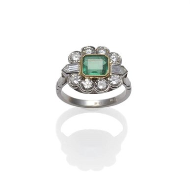 Lot 376 - An Emerald and Diamond Cluster Ring, the emerald-cut emerald in a yellow collet setting, within...