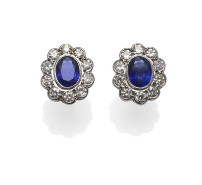 Lot 379 - A Pair of Sapphire and Diamond Cluster Earrings, the oval mixed cut sapphires within a border...