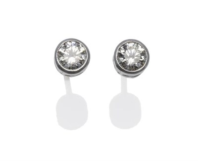 Lot 384 - A Pair of Diamond Solitaire Earrings, the round brilliant cut diamonds in white collet...