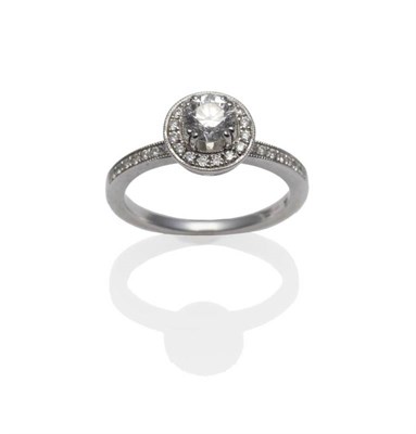 Lot 386 - An 18 Carat White Gold Diamond Ring, a round brilliant cut diamond within a disk frame inset...