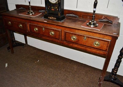 Lot 386 - A Georgian oak dresser base on square tapering legs