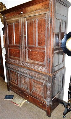 Lot 387 - Carved oak cupboard with fielded panel door and drawers below