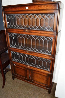 Lot 390 - An oak stacking bookcase with leaded glazed panels