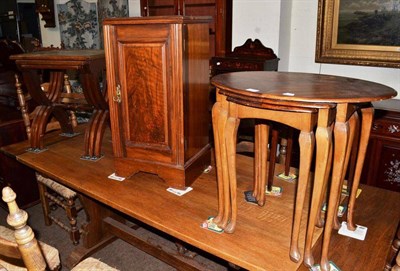 Lot 413 - A walnut bedside cabinet, two nests of tables and a small tray top table