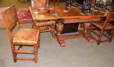 Lot 499 - An oak draw leaf refectory table and four leather upholstered chairs