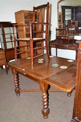 Lot 522 - A pair of Edwardian mahogany elbow chairs with caned seats and an oak draw leaf dining table