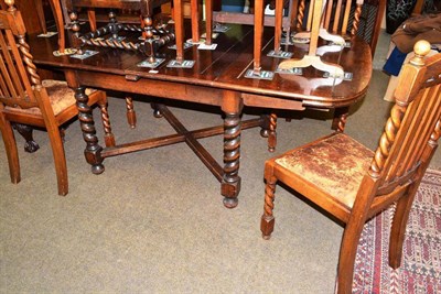 Lot 525 - A set of four oak dining chairs and an oak draw leaf dining table on barley twist legs