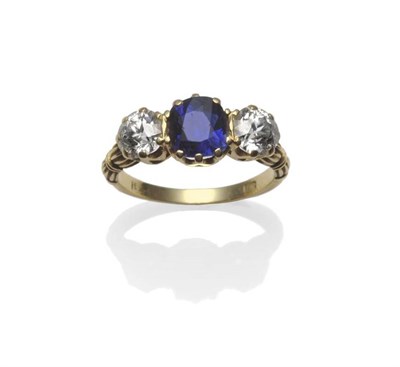 Lot 411 - A Late Victorian Sapphire and Diamond Three Stone Ring, the cushion cut sapphire flanked by an...