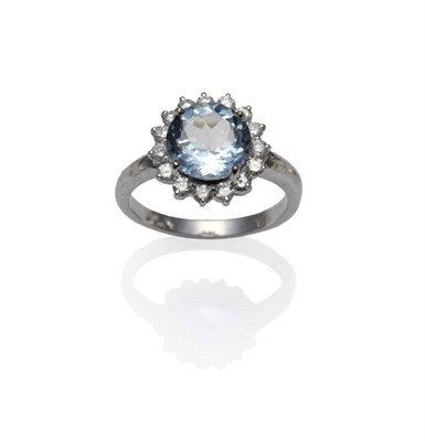 Lot 417 - An Aquamarine and Diamond Cluster Ring, a round brilliant cut aquamarine within a border of...