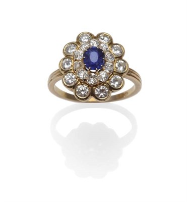 Lot 419 - A Sapphire and Diamond Cluster Ring, the oval mixed cut sapphire within a border of old cut...