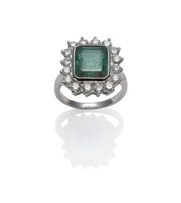 Lot 421 - An Emerald and Diamond Cluster Ring, the emerald-cut emerald within a white rubbed over...