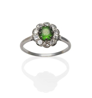 Lot 431 - A Demantoid Garnet and Diamond Ring, the round brilliant cut garnet within a border of ten...