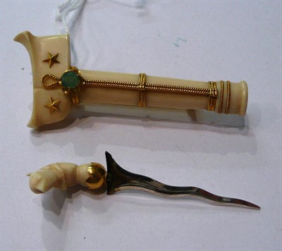 Lot 112 - An ivory brooch with enclosed pick set with an emerald (possibly a Malaysian crest)