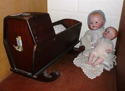 Lot 145 - Armand Marseille bisque socket head baby doll, another and a small dolls cradle (3)