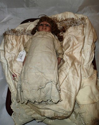 Lot 193 - A bisque headed doll and a cream wool embroidered cape