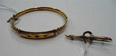 Lot 230 - A 9ct gold bangle (cased) and a 9ct gold bar brooch modelled as a horseshoe (2)