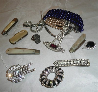 Lot 335 - A box of costume jewellery, three brooches and a clip, four mother of pearl penknives, costume...