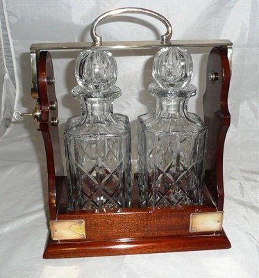 Lot 381 - A mahogany two bottle tantalus with plated mount