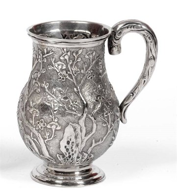 Lot 462 - A Chinese Export Mug, bears silver marks for Wang Hing, the baluster body chased with flowering...