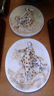 Lot 484 - A pair of Continental bisque wall plaques depicting maidens with cherubs